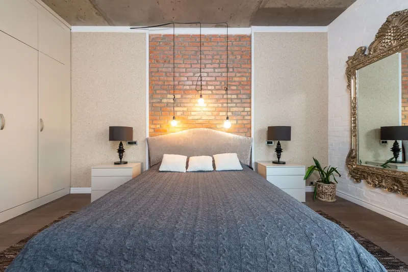 Contemporary bedroom featuring a stylish brick accent wall and elegant decor