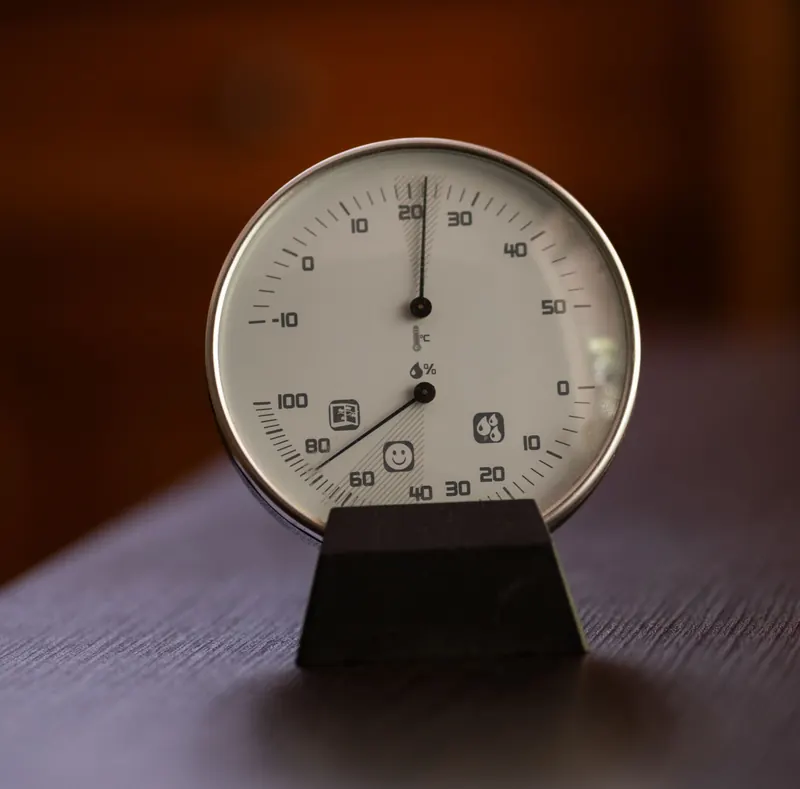 Close-up of an analog hygrometer and thermometer displaying temperature and humidity indoors