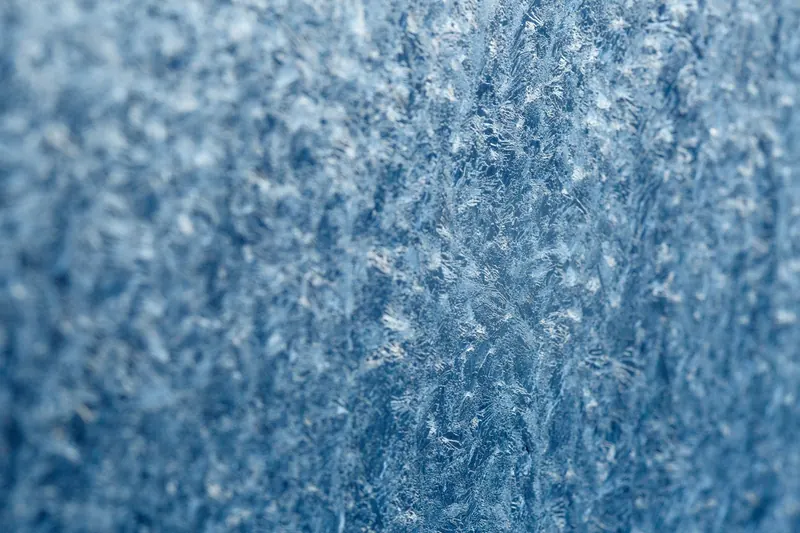 Detailed macro shot of intricate frost texture on a window during winter