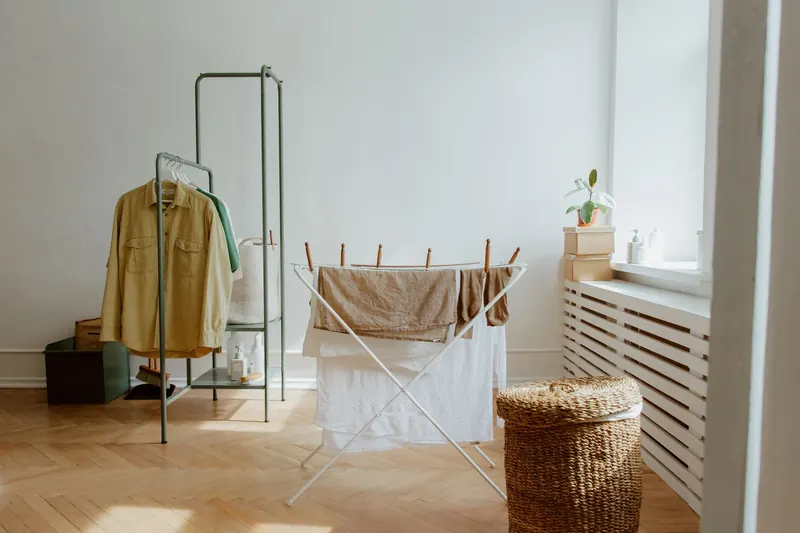 A laundry room with natural light and organized clothes drying setup