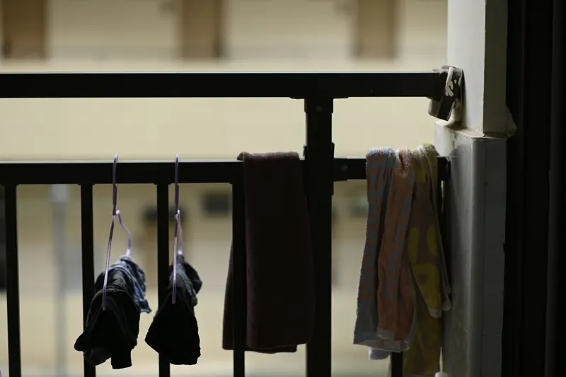 Clothes and towels hung for drying on an indoor balcony rail, creating a homey atmosphere