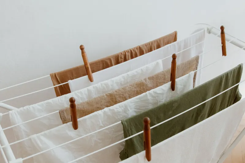 A minimalist image of clothes drying on a rack indoors, showcasing neatness and order